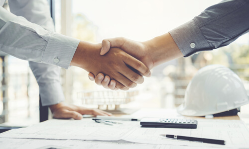遮熱塗料や建物改修でSDGsに取り組むことができた企業と施工会社が握手するイメージ