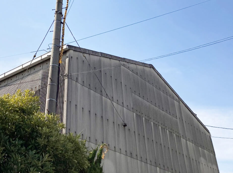 工場・倉庫の劣化したスレート屋根の雨漏りを補修し断熱効果もある防水工事リリーフ工法（カバー工法）の直接工法 外壁新工法施工前の外壁